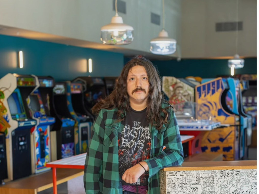 Chef Diego Argoti of Estrano, standing beside a row of arcade cabinets